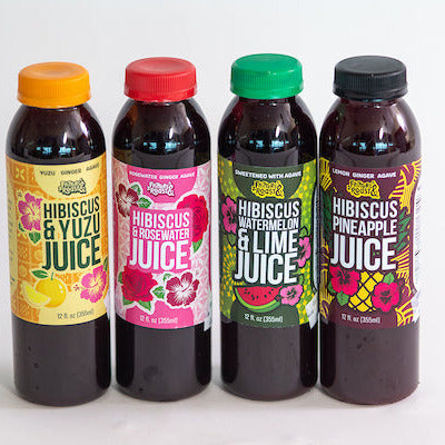 Four bottles of hibiscus juice with colorful labels on a white background